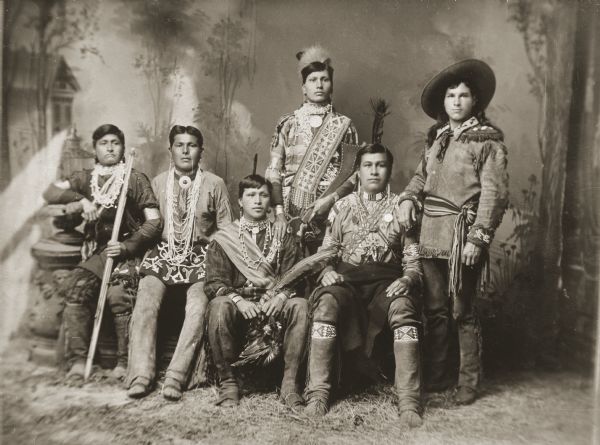 In this photograph, copied by Van Schaick from another photographer, Wild West show promoter Tom Roddy is standing on the far right, along with his cast of performers, in front of a painted backdrop. From left to right are: Thomas Hunker (WaConChaKeeKah), John Whitedog (ChaShepSkaKah), George Littlegeorge (KayRayChaSekSkaKah), Jake Decorra Whiterabbit (MuaHeRooZhooKah), and George Blackhawk (WonkShiekChoNeKah).