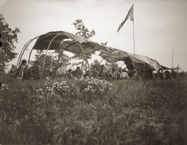A view of the Thunder Clan Feast Lodge. The flag is British and came to the Ho-Chunk when they joined forces with the British against the United States during the War of 1812.