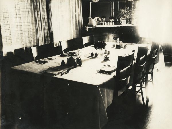 Dining room table illuminated by sunlight from a nearby window, located at the Winnebago County Asylum.
