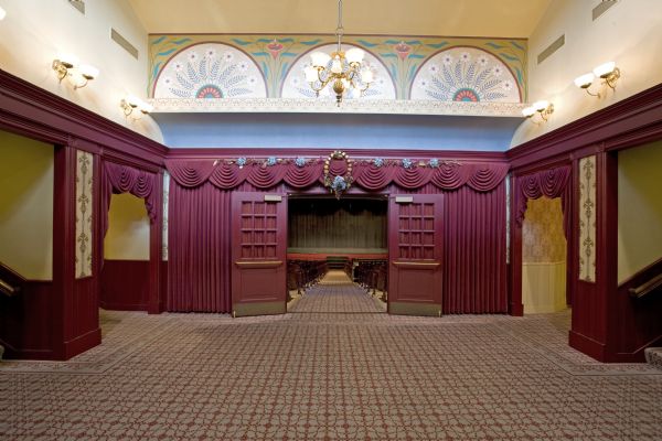 Lobby of Grand Opera house, including Frank Waldo decorative designs above auditorium doors, featuring lilies and other flowers.