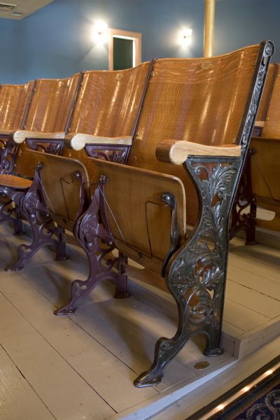Close-up of theater seating in Stoughton Opera House with top hat racks.