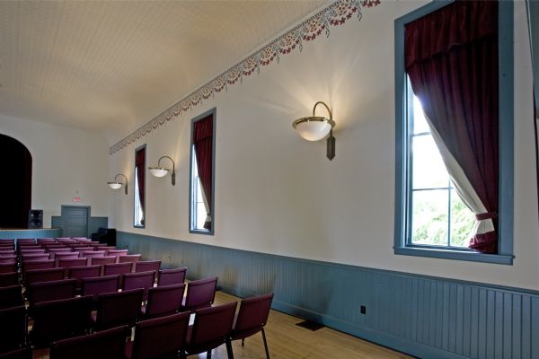 Interior view of Thrasher Opera House auditorium wall with replicated stencil work and period replica sconces.