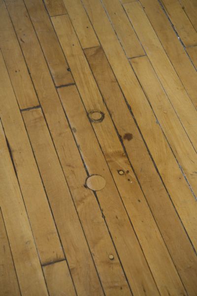 Close-up of Thrasher Opera House floor showing repair of holes made for sewing machine conduits.