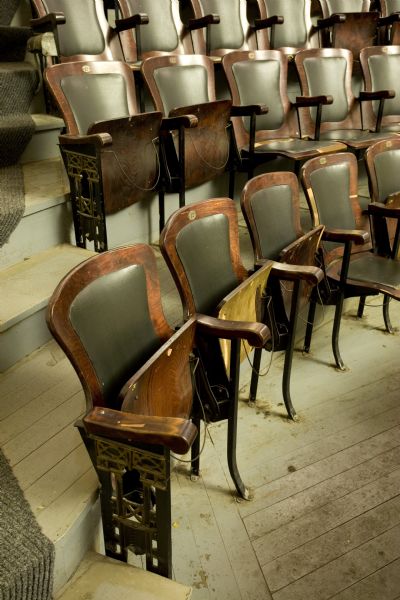 Close-up of original chairs in Mineral Point Opera House's balcony including hat racks.