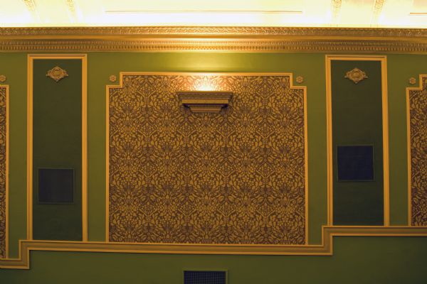 Close-up of floral patterned stencil work, restored plasterwork details and gilded wall panels in the the Temple Theatre.