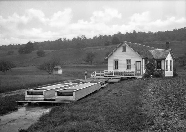 A trout hatchery at the Flat Brook Valley Club. A hill and wooded area is in the background.