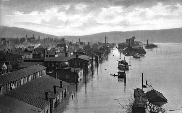 Elevated view of Second Street and surrounding area during a flood of the Ohio River. Some buildings are submerged up to their roof lines and the street resembles a lake or river.