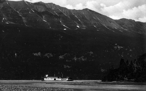 View of a riverboat on Copper River with the Chugach Mountains rising in the background.
