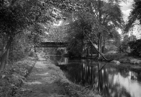 A view of Morris Canal and a bridge from a path alongside in a country setting.