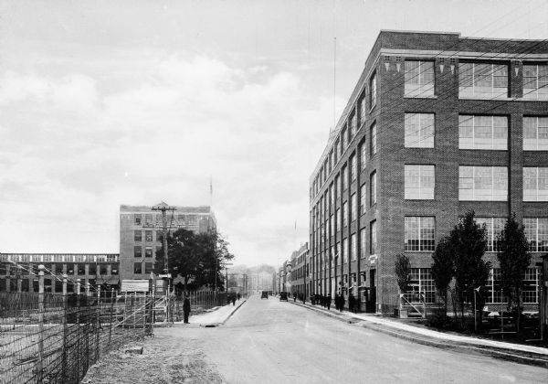 The New Bond Street Section of the Norton Grinding Company showing brick buildings, a road and fenced areas.