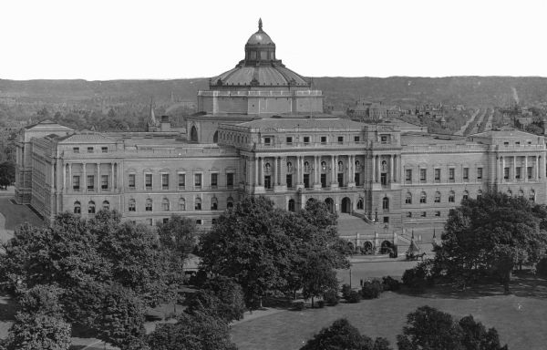 Elevated view of the Thomas Jefferson Building of the Library of Congress from a nearby park hill showing the tiered and columned facade as well as the ornamented dome.