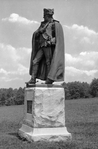 Close-up of a bronze statue of Major General Friedrich Wihelm Baron von Steuben of the Continental Army during the American Revolutionary War.  Installed in 1915, the J. Otto Schweizer statue stands atop a rough-hewn stone pedestal in an open field.
