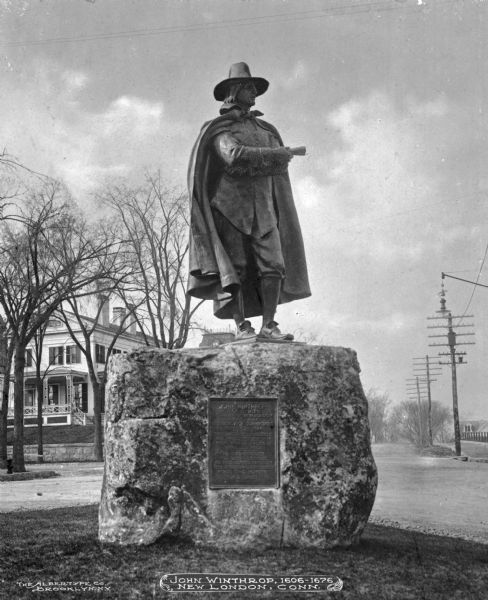 Published by the Albertype Company of Brooklyn, New York, the image features Bela Lyon Pratt's statue honoring Governor John Winthrop Jr., once Governor of Connecticut. The bronze which was unveiled on May 6, 1905 depicts Winthrop in a cloak holding a document and standing atop a weathered block of stone. A mansion is visible in across the street behind the statue.