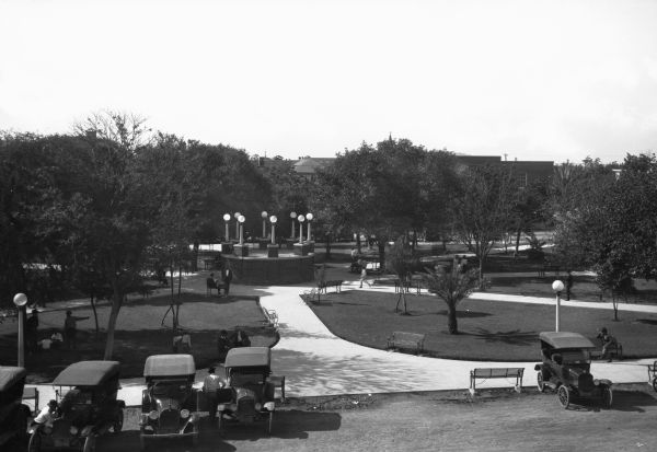 Elevated view of Jarvis Park showing parked cars, grass, trees and paved paths leading to a central lighted platform.