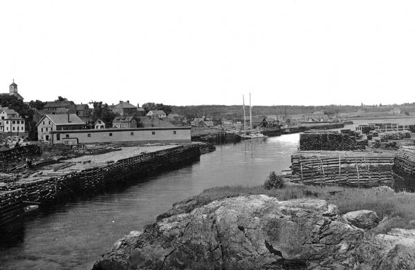 Elevated view of the harbor with wharves loaded with lumber.