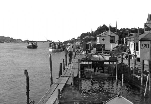 Fishing boats and a wharf along a canal. A bait shop is in the foreground.