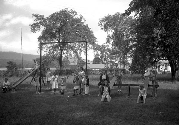 A view of children playing on a slide, swings, and see-saws at the playground at S.F.S. Holiday House.
