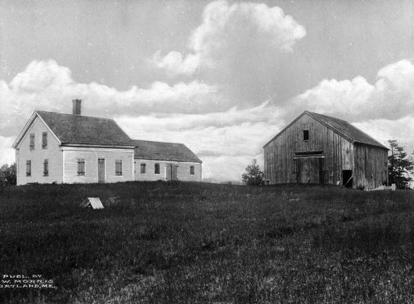 A view of a deserted farmhouse and barn.