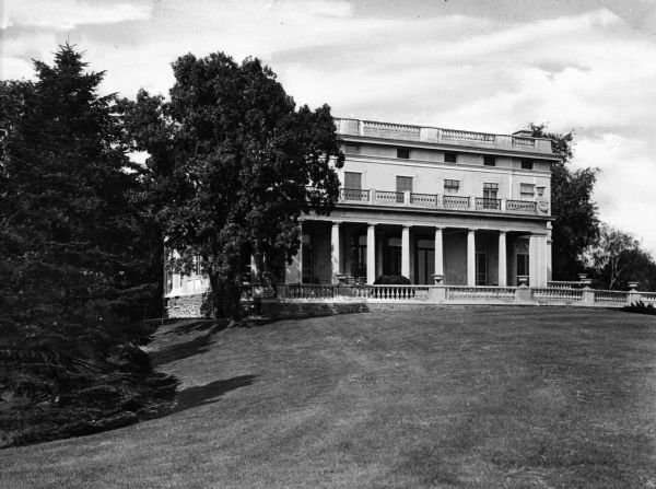 View across lawn toward a house on the Walhall Estate, built with Doric columns.