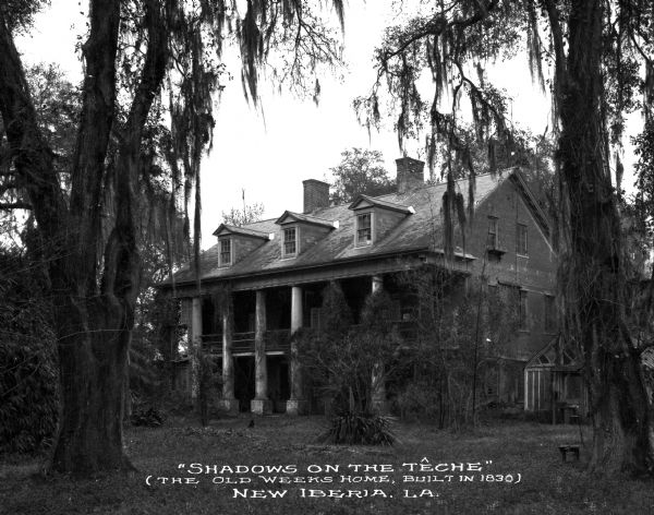 The Old Weeks Home, known as "Shadows-on-the-Teche," was a white-columned brick residence built in 1830. The home was a backdrop for several events during the Civil War, as well as the stage for business entrepreneurs, politicians, and soldiers. Caption reads: "'Shadows on the Teche' (The Old Weeks Home, Built in 1830) New Iberia, LA."