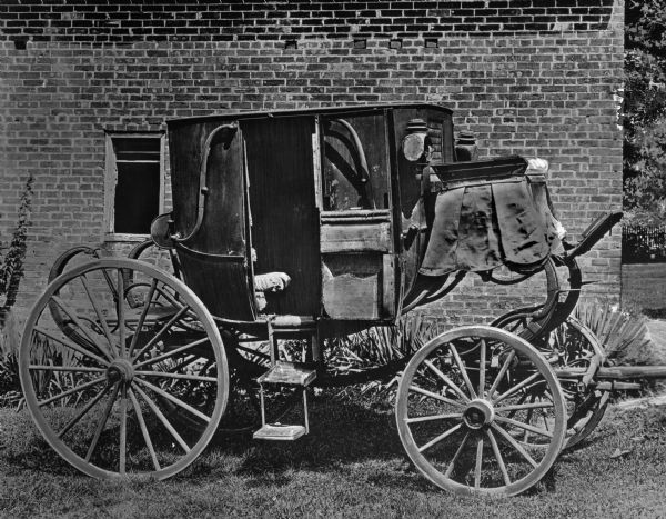 The state coach belonging to Andrew Jackson, the seventh President of the United States (1829–1837). View of the right side of the coach. A brick building is behind the coach.