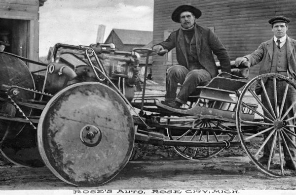 Two men, presumably from Rose's Auto, pose with a homemade automobile with wagon wheels. Caption reads: "Rose's Auto, Rose City, Michigan."