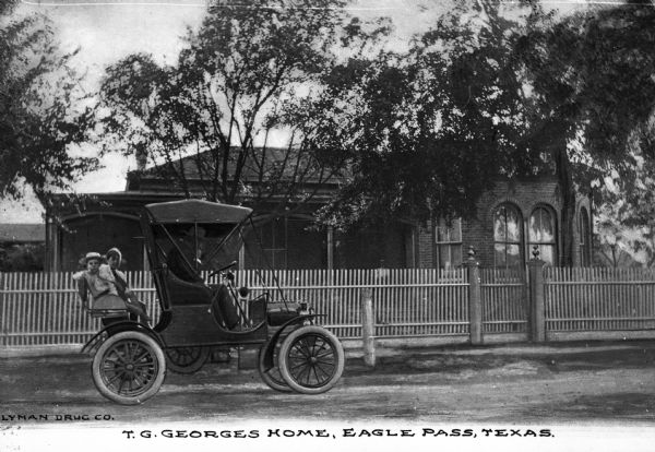 The residence of T.G. George with people in a car in front. Caption reads: "T. G. Georges Home, Eagle Pass, Texas."