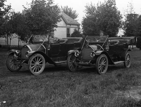 Overland Company of Illinois was saved from a multitude of financial issues by John Willys, a skillful salesman, in 1907. Shown in this photograph are men sitting in two of at least eleven basic models of touring cars that Overland has produced.