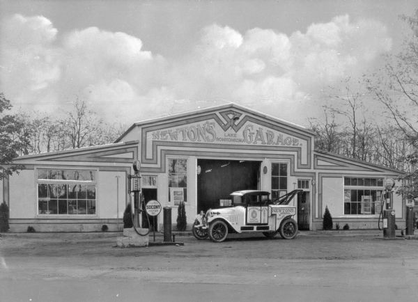A view of a gas station, Newton's Garage, and a repair truck.