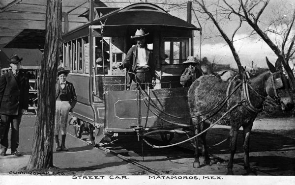 Men and a boy pose near a man driving a mule-drawn street car. Caption reads: "Street Car. Matamoros, Mex."