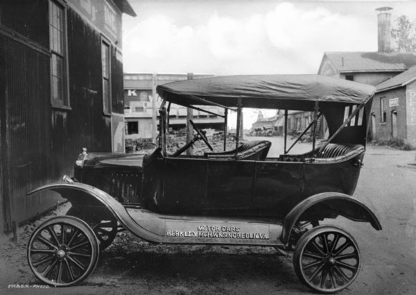 Ford touring car fitted with flanged wheels to run on track at Berkeley Machine Works Inc. Plate on driver's side of car near the running board reads: "Motor Cars Berkley Mch Wks, Norwalk, VA."