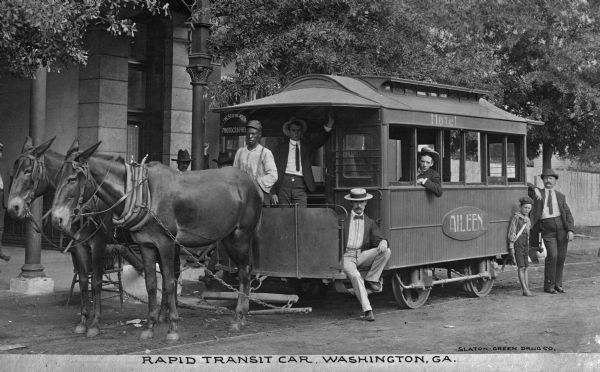 A group of men and a boy pose near the rapid transit car labeled, "Aileen" and "Hotel." Caption reads: "Rapid Transit Car, Washington, GA."