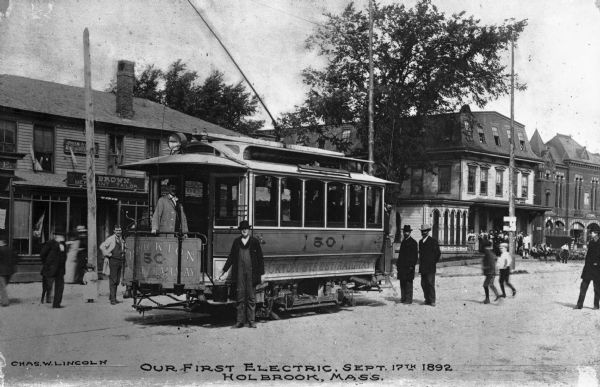 "Our First Electric," a trolley car on a town street with men posing. Caption reads: "Our First Electric, Sept. 17th 1892. Holbrook, Mass."