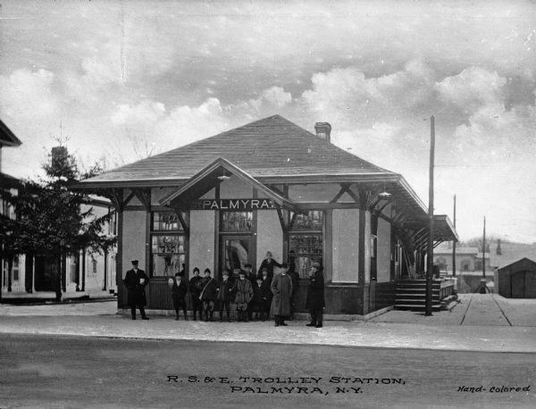 Palmyra was a stop on the Rochester, Syracuse and Eastern Railroad Route. A group of people are waiting outside the station for the trolley. Caption reads: "R. S. & E. Trolley Station, Palmyra, N.Y."