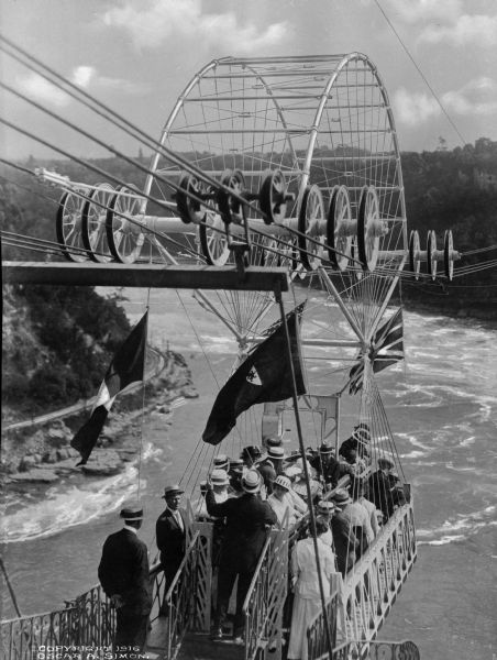 Slightly elevated view of people in the Whirlpool Aero Car, opened in 1916, departing from the station and crossing the whirlpool of Niagara Falls.