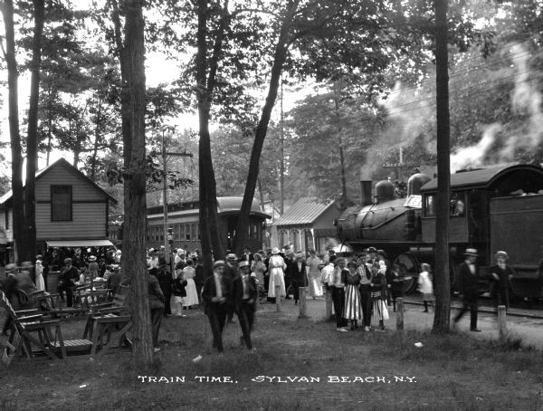 The station at Sylvan Beach was essential in providing transportation to central New York's recreational resort area. Caption reads: "Train Time. Sylvan Beach, N.Y."