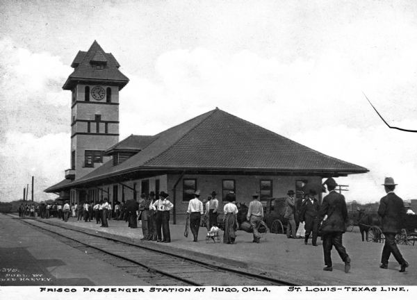 The St. Louis-San Francisco Railway Station was incorporated in Missouri on September 7, 1876. At the Hugo stop, seven passenger trains ran through daily. Caption reads: "Frisco Passenger Station at Hugo, Okla. St. Louis-Texas Line."