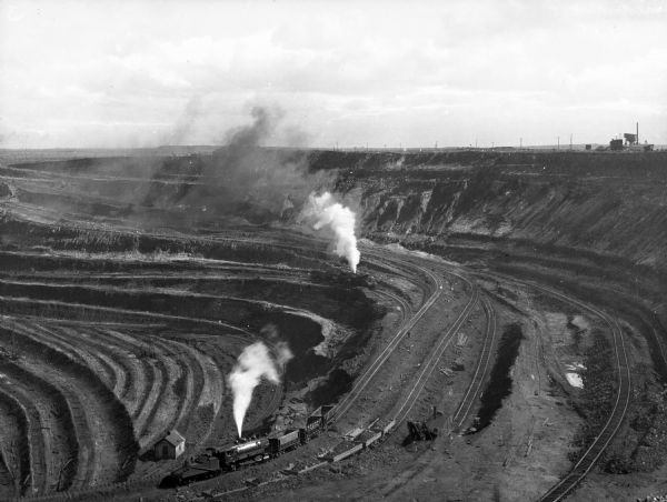 Two trains transporting taconite from Susquehanna Open Pit Iron Ore Mine, part of the Mesabi Iron Range, discovered in 1866.