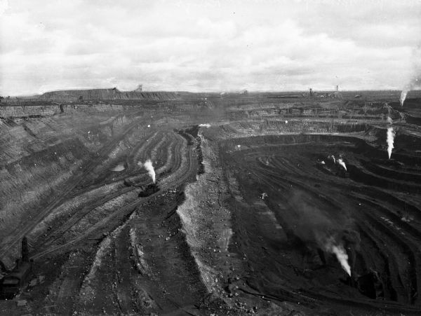 Elevated view of steam shovels at work, removing taconite from Susquehanna Open Pit Iron Mine, functioning as an open cast mine because of its soft, shallow ore deposits.