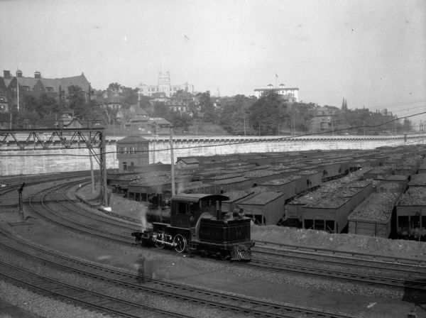Trains transported iron ore through St. George every twenty minutes. A view of the city can be seen behind the railroad yard.