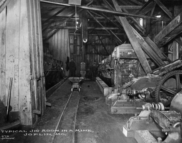 Soon after the turn of the century, Joplin was named the lead and zinc capital of the world. A jig room is shown with a miner. Caption reads: "Typical Jig-Room in a mine. Joplin, MO."