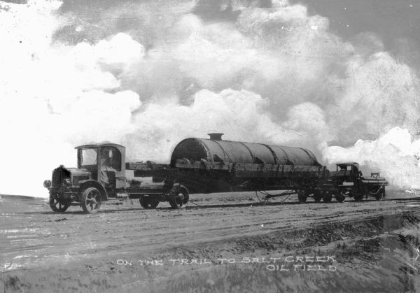 An oil truck on it way to Salt Creek oil field, at one time responsible for producing approximately one-fifth of all petroleum in the United States. Caption reads: "On the trail to Salt Creek Oil Field."