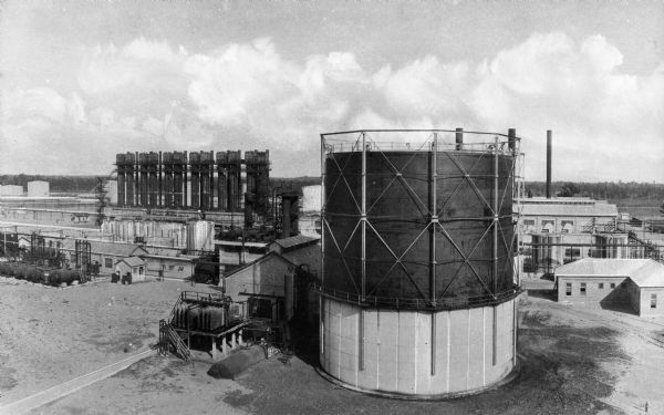 A large circular structure stands in the foreground of the Atlantic Refining Company Plant, the first refinery in the United States, established by Charles Lockhart in 1865.