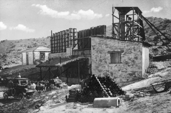 Workers stand near an automobile and pack of mules in Mariscal Mine. The mine produced 1,400 flasks of mercury, 1/4 of the US production, between 1900 and 1943.