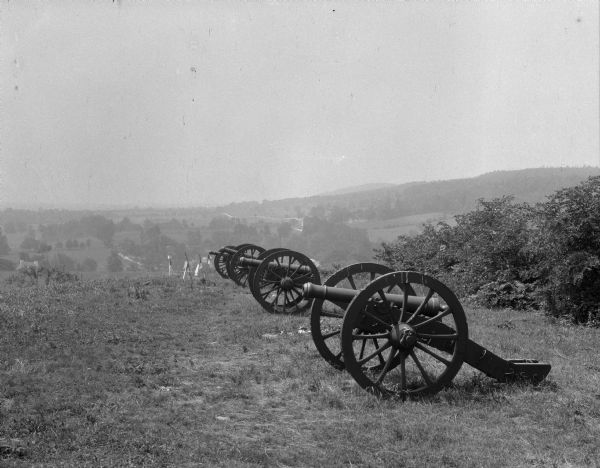 A view of Lunette Batteries. Canons stand in a line and United States flags are lined up into the distance.