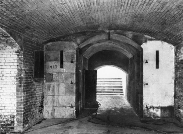 Interior view of Fort Sumter.  Two open doors show a staircase in the distance, and two dates, "1776" and "1917" are written on the wall.  Construction on the fort began in 1827.