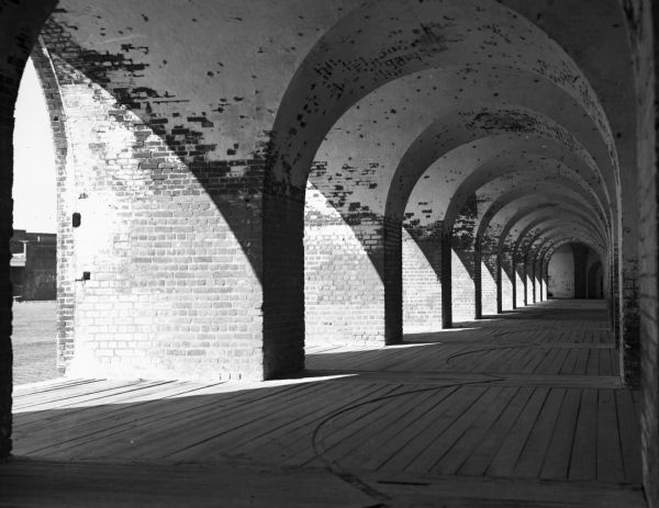 Light shines through the arches of a portico onto the walkway of Fort Pulaski, completed in 1847.