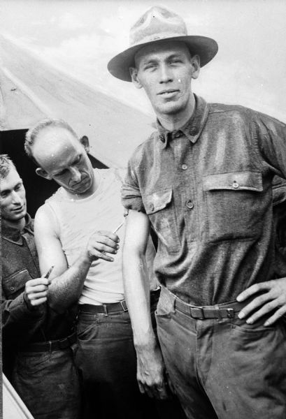 A recruit receives inoculations from two men on the left at Camp Travis, named in 1917 after William B. Travis.