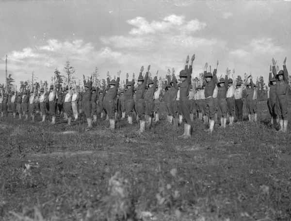 Soldiers raise their arms during an exercise session in a field at Camp Upton, created in 1917.