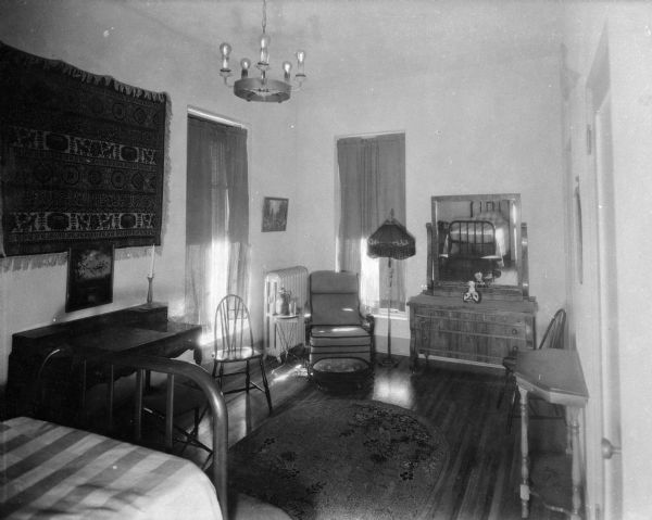 Interior of a bedroom at Saint Mary's Sanatorium, founded in 1880 by Bishop Salpointe. The view includes a bed, chairs, a dresser, and desk.